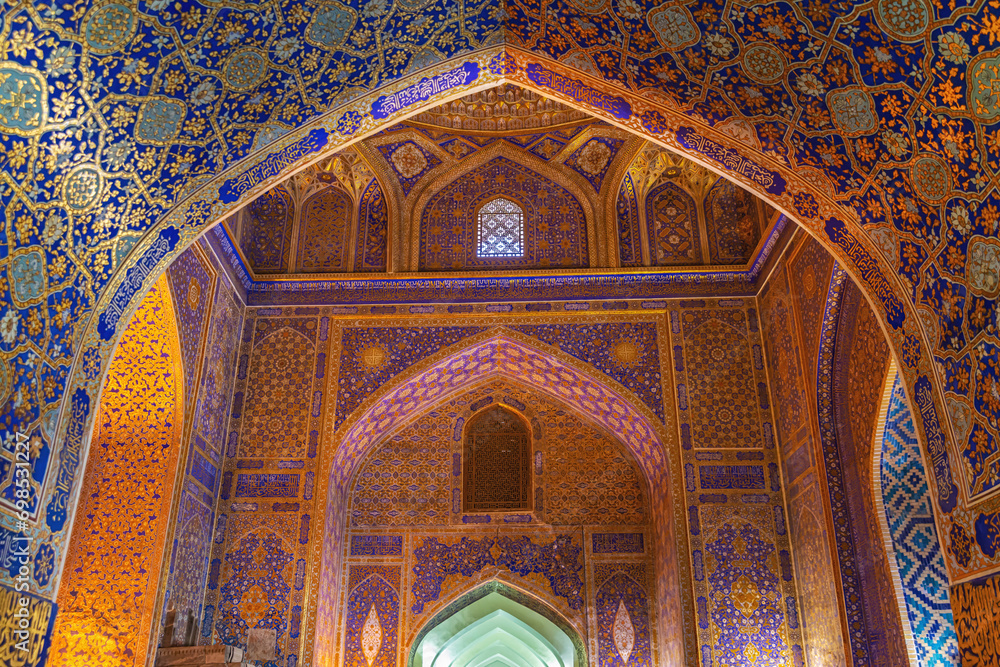 Interior of Madrasa Tilya Kori. Rich traditional ornaments with blue and gold. Arabic text of Qran (sacred book of muslims) used as part of ornament. Samarkand, Uzbekistan