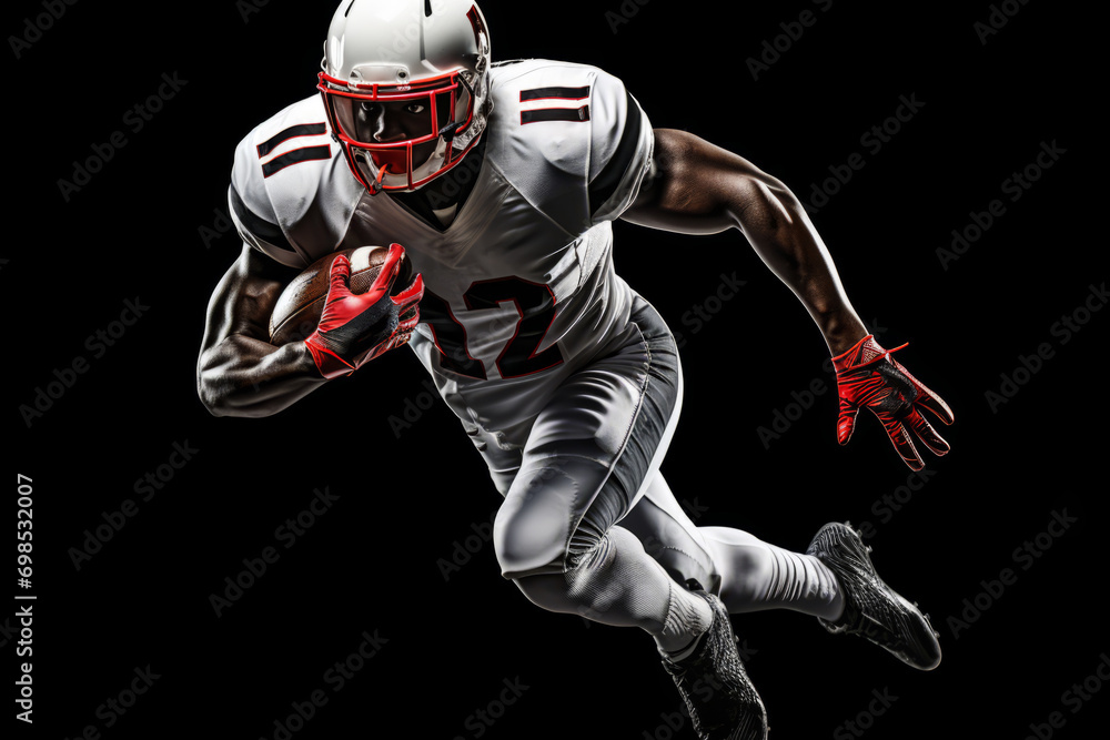 Portrait of American football player running with the ball. Muscular athlete in a white and red uniform with an ovoid ball in a dynamic pose. Isolated on black background.
