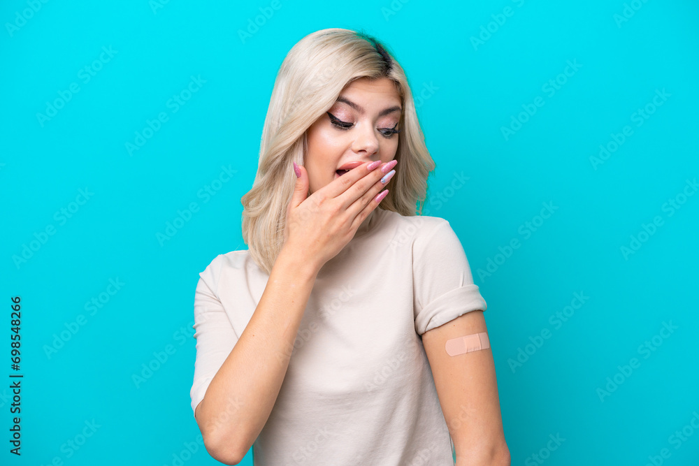 Young Russian woman wearing band aid isolated on blue background with surprise and shocked facial expression Young Russian woman wearing band aid isolated on blue background with surprise and shocked facial expression