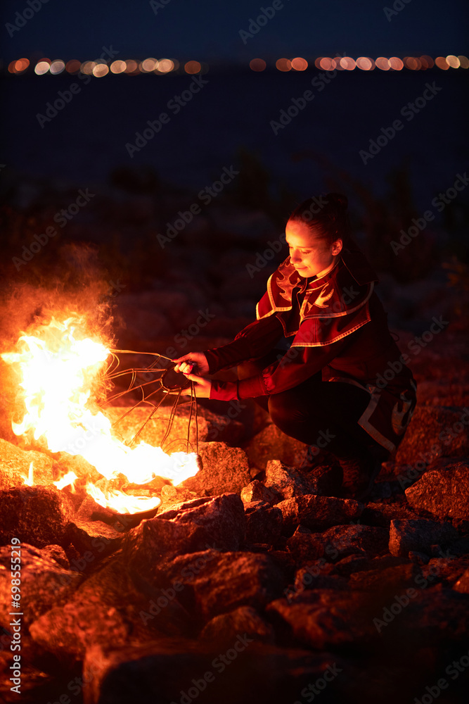 Full length portrait of young woman holding fire fans performing outdoors at night Full length portrait of young woman holding fire fans performing outdoors at night