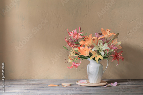beautiful lily in white jug on wooden table