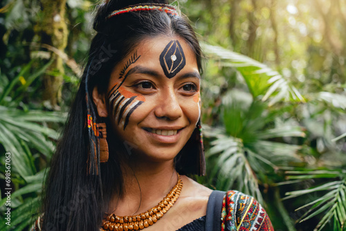 Portrait indigenous woman with face painted with tribal motifs in the jungle