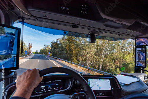 View from the driver's position of a truck on the road of the interior of the cabin with the screens as rearview mirrors and the GPS on the dashboard screen. photo