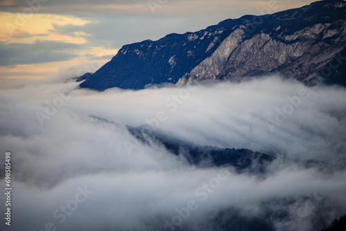 Mountainous expanse cloaked in mist.