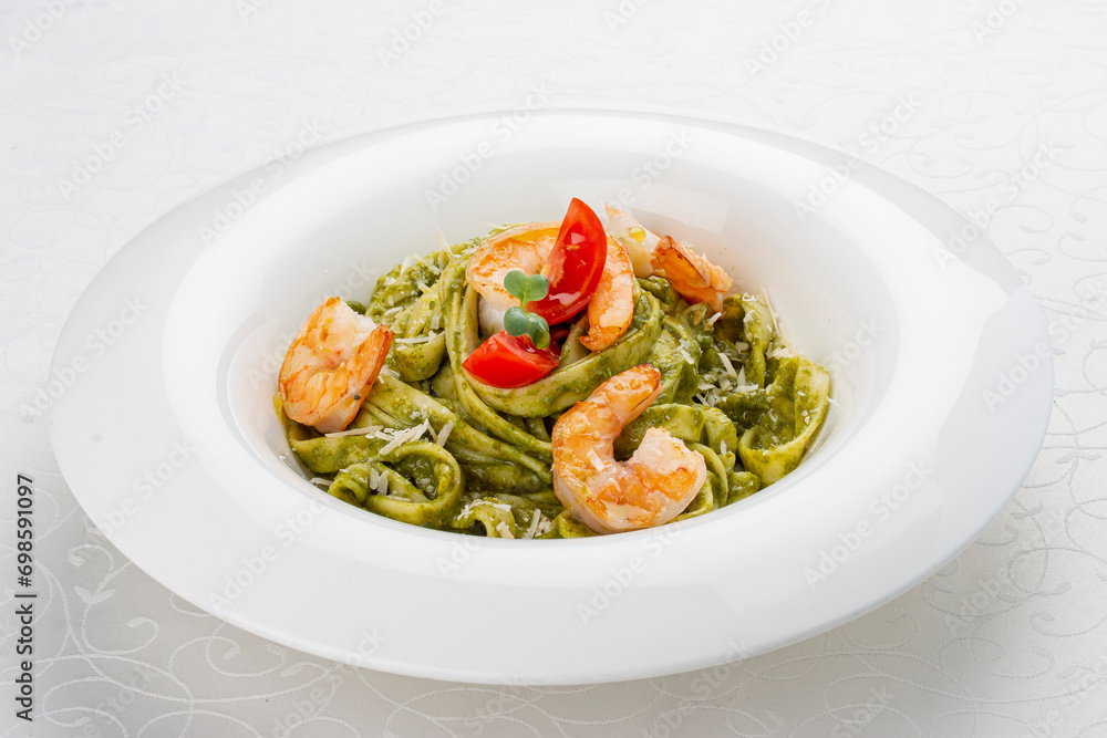 Fettuccini with shrimp and pesto sauce. Isolated image Fettuccini with shrimp and pesto sauce. Isolated image