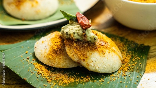 Idli or Idly  is a popular south Indian food, served with coconut chutney on a banana leaf. idly, idle, south indian food idle or idly
 photo