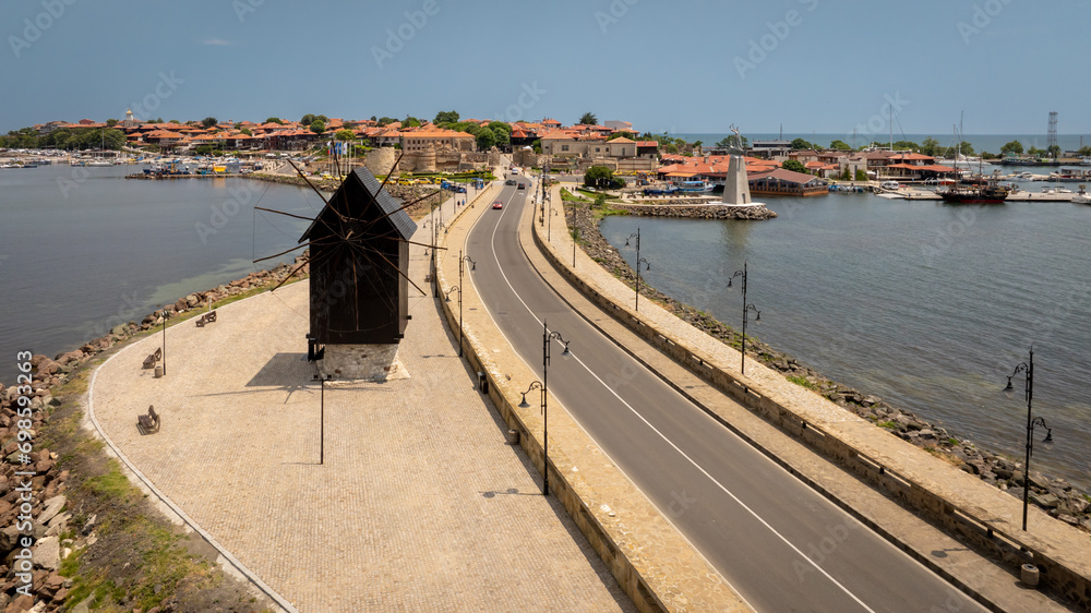 Old windmill at the entrance to the Old Town of Nessebar, ancient city on the Black Sea coast of Bulgaria. Aerial view.
