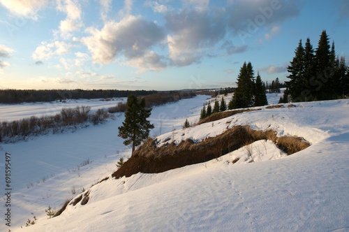 a snowy hill in the rays of the setting sun