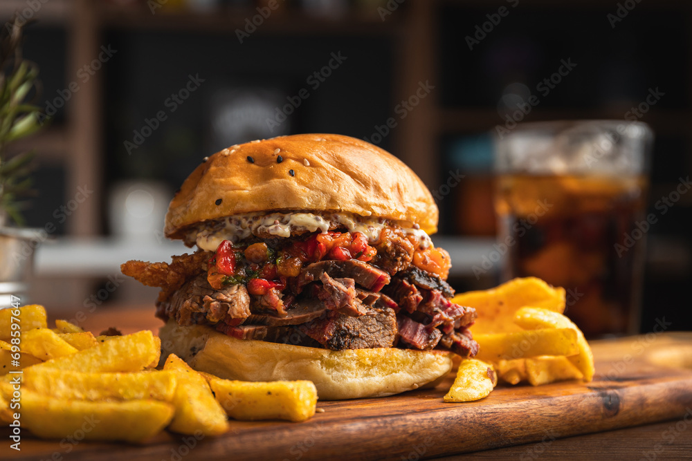 Brisket sandwich with sweet pepper, caramelized onion and aioli sauce served with a portion of French fries
