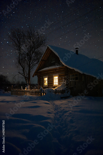 Village house on a winter evening snow stars