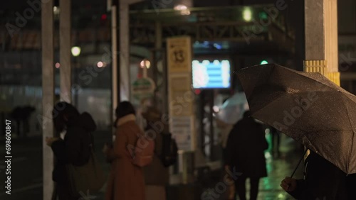 雨が降る夜,バス停で待機する人々 photo