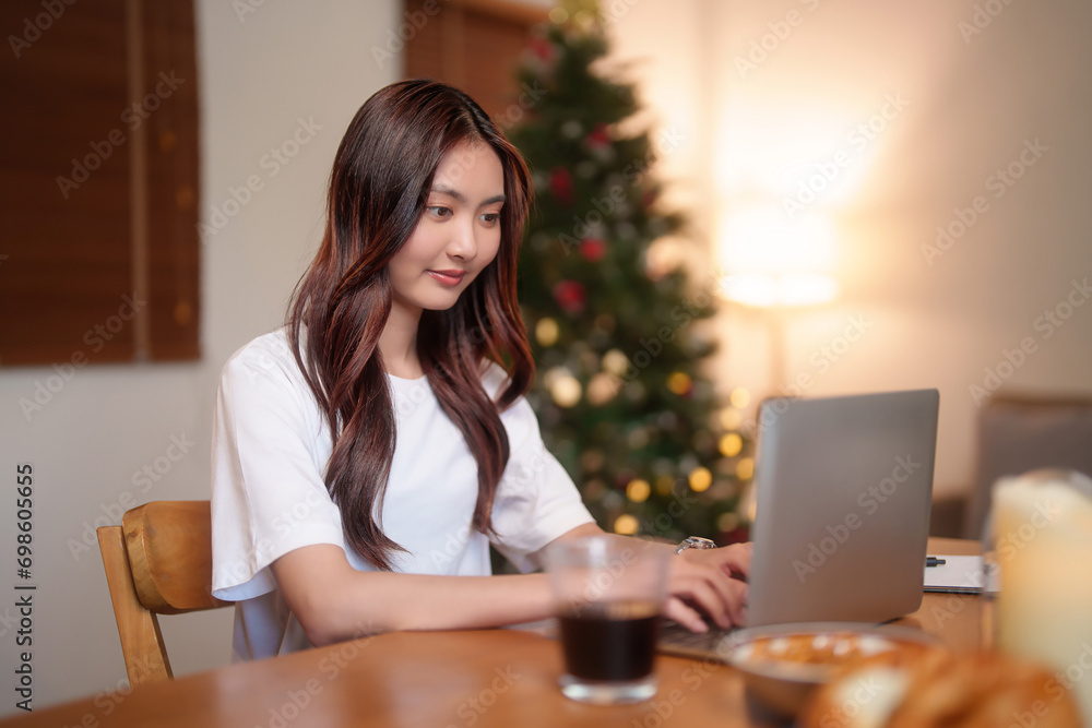 Young asian women using digital laptop to reading financial report and typing data on keyboard while working and analysis about marketing strategy of new startup project in living room at home office Young asian women using digital laptop to reading financial report and typing data on keyboard while working and analysis about marketing strategy of new startup project in living room at home office