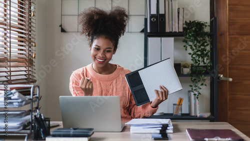 African american businesswoman holding document and raise arm to celebrate with work successful