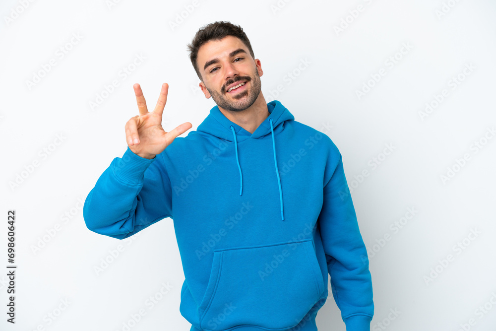 Young caucasian man isolated on white background happy and counting three with fingers Young caucasian man isolated on white background happy and counting three with fingers