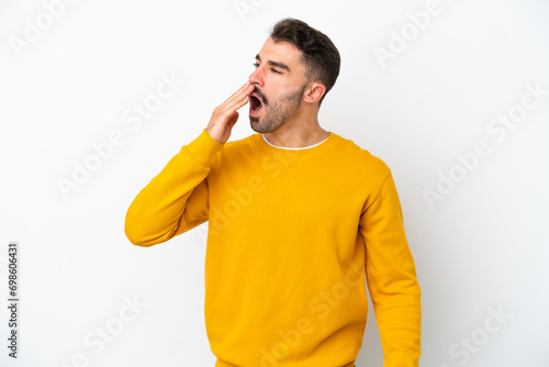 Young caucasian man isolated on white background yawning and covering wide open mouth with hand