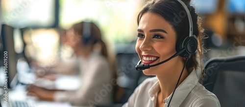 Smiling woman in call center with headset, happy agent providing customer service and support at help desk. photo