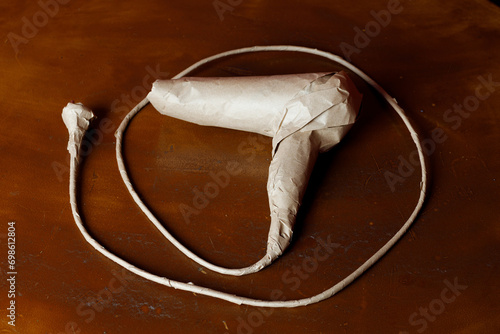 A brand new hair dryer with wire wrapped in rustic beige craft paper. Black Friday shopping concept.