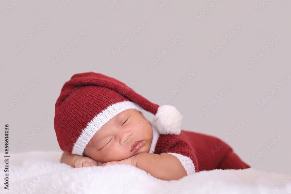 child in santa claus clothes sleeping on fluffy bed. child in santa claus clothes sleeping on fluffy bed.