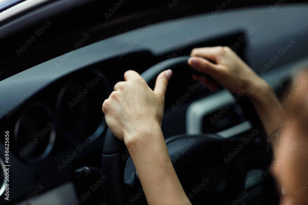 Happy woman driver hands close up holds steering wheel car.