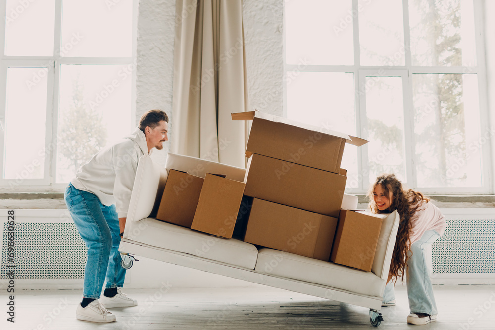 Ταπετσαρία Happy young family couple man and woman lift and carry sofa with cardboard boxes in new home