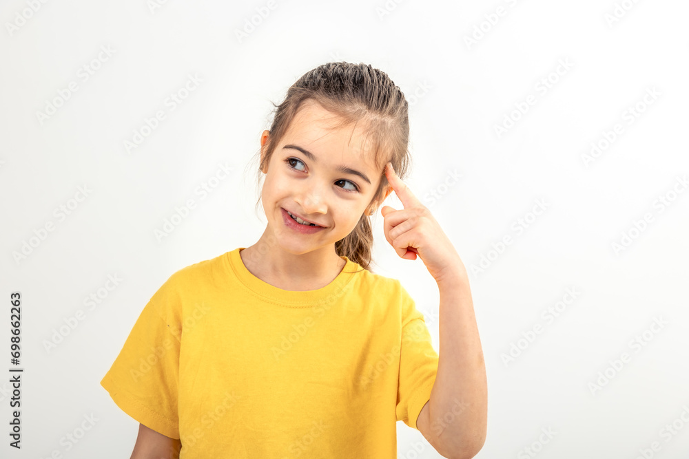 Little girl school girl points her finger up on white background isolated. Little girl school girl points her finger up on white background isolated.