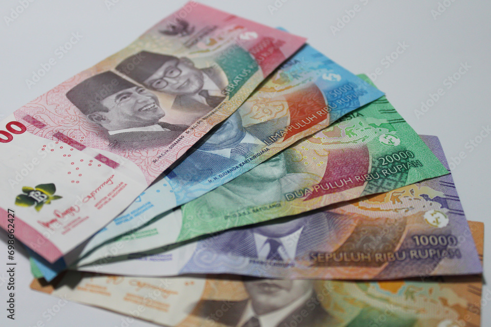 Obraz premium Colorful Indonesian rupiah bank notes against a white background