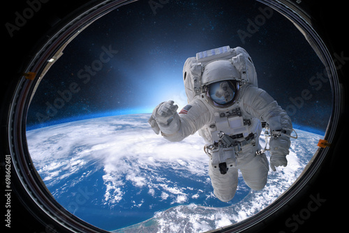 Astronaut in outer space from porthole on background of the Eart