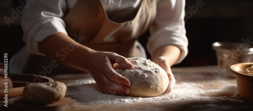 Professional baker woman preparing dough for bread such as sourdough or artisan bread on kitchen table photo