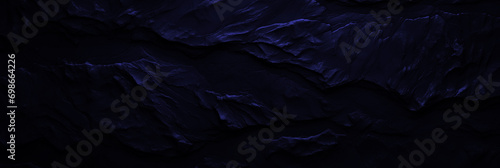 Wide navy stone background for banner design. Blue rock grunge texture. Mountain surface close-up cracked empty copy space