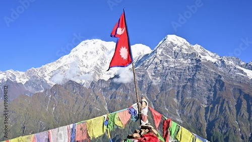 Nepali flag with beautiful view of Mt.Annapurna South (7,219 m) and Mt.Hiunchuli (6,441 m) seen from Mardi Himal view point in the Annapurna region of Nepal. photo