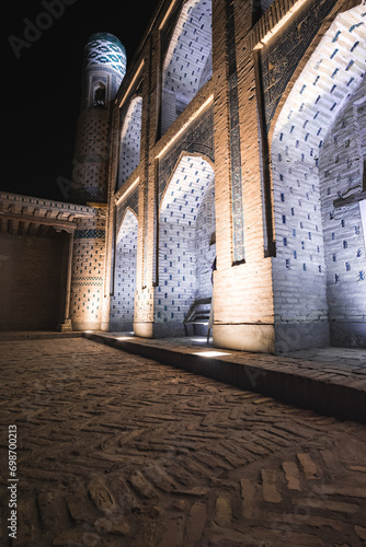 Mohammed Rakhim Khan Madrassah illuminated by lanterns and spotlights in the evening in the ancient city of Fort Khiva in Khorezm, night exterior of the facade of the mausoleum photo