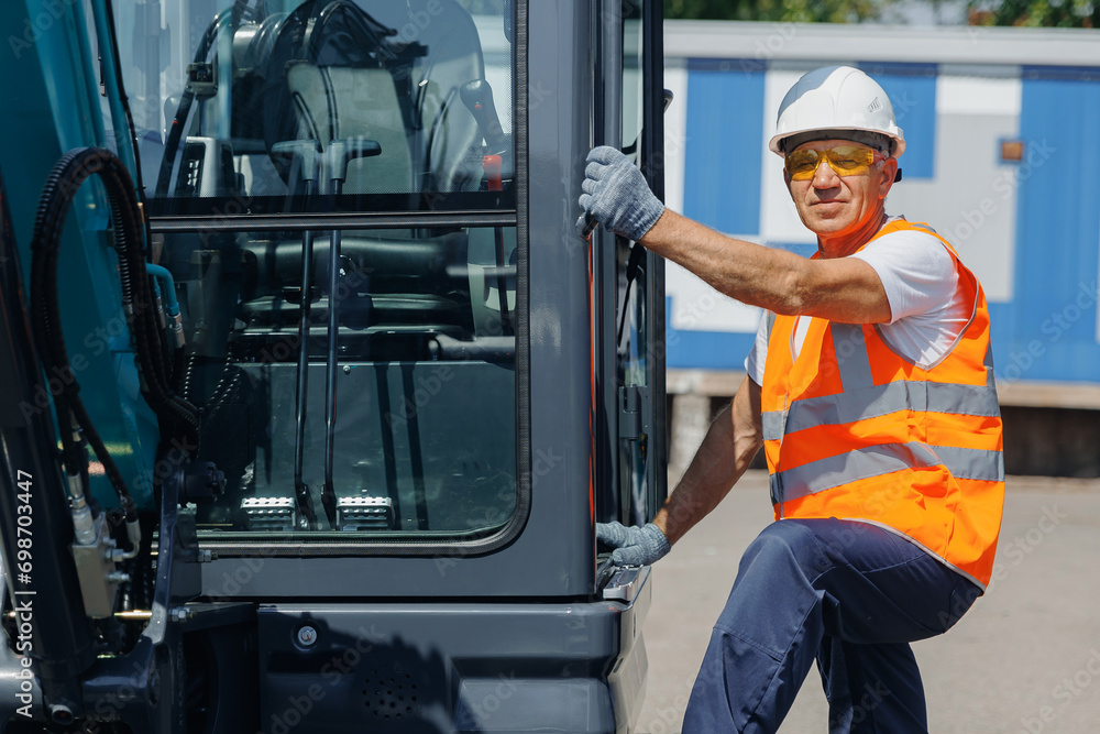 Man driver builder operate crane or excavator at construction site. Industry worker portrait Man driver builder operate crane or excavator at construction site. Industry worker portrait