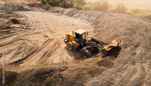 Aerial top view yellow industrial excavator working on sand quarry. Concept Open pit mine industry