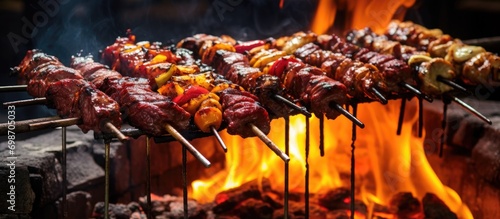 Assorted meats on skewers, grilled over charcoal and fire, in traditional street food style. photo