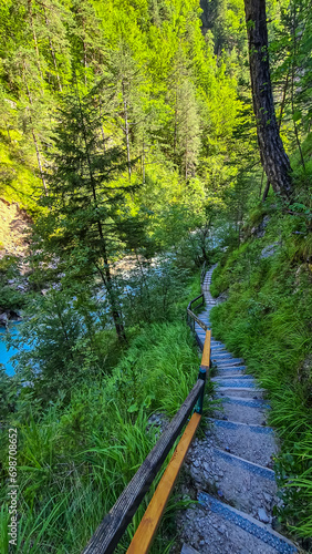 Scenic hiking path through the gorge of Tscheppaschlucht, Loibl Valley, Karawanks, Carinthia, Austria. Narrow canyon, unique rock formation in forest. Constructed walkway along cliffs and rocks