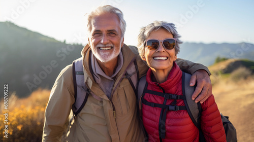 Portrait of an elderly couple enjoying their hike in mountains, having a lovely moment together with natural lights