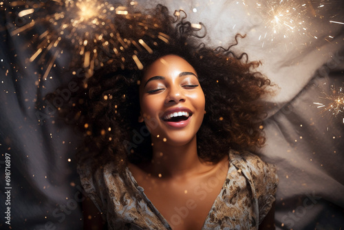 Young african american woman having orgasm. Beautiful woman with closed eyes enjoying sex lying among fireworks. Sparklers as a symbol of orgasm. Sexual experience, masturbation, cunnilingus.