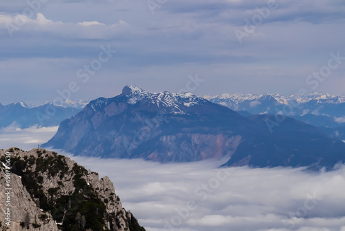 Scenic view of mountain peak Schwarzkogel and Dobratsch in Karawanks mountains in Carinthia, Austria. Magical atmosphere in remote landscape in Slovenian Austrian Alps. Misty fog and clouds in valley
