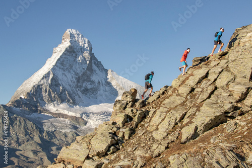 Climbers ascending a steep rocky slope photo