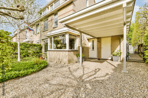 Front of brick house with gravel driveway photo