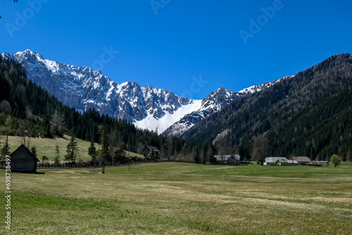 Alpine meadow of the Maerchenwiese with panoramic view of Karawanks mountains in Carinthia, Austria. Looking at snow capped summit of Vertatscha and Hochstuhl. Remote alpine landscape in Bodental