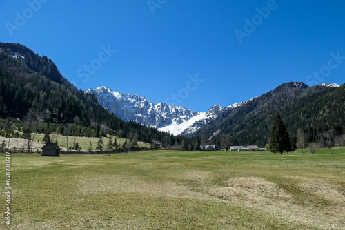 Alpine meadow of the Maerchenwiese with panoramic view of Karawanks mountains in Carinthia, Austria. Looking at snow capped summit of Vertatscha and Hochstuhl. Remote alpine landscape in Bodental photo