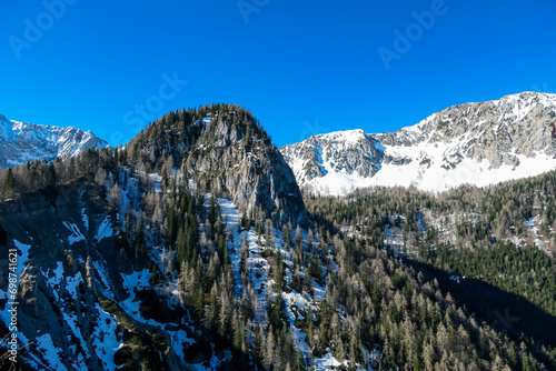 Panoramic view of Karawanks mountain range on sunny day in Carinthia, Austria. Looking at snow capped summit of Vertatscha and Hochstuhl. Remote high alpine landscape in Bodental, Austrian Alps photo