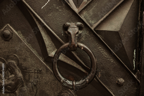A ram's head knocker on a door, detail of iron door at city street of Krakow. High quality photo