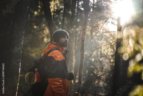 Man explorer standing in autumn forest on sunny day photo