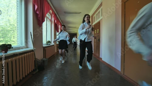The students are running down the hallway of the school. photo