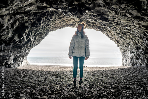 Woman alone inside Reynisfjara cave in Iceland