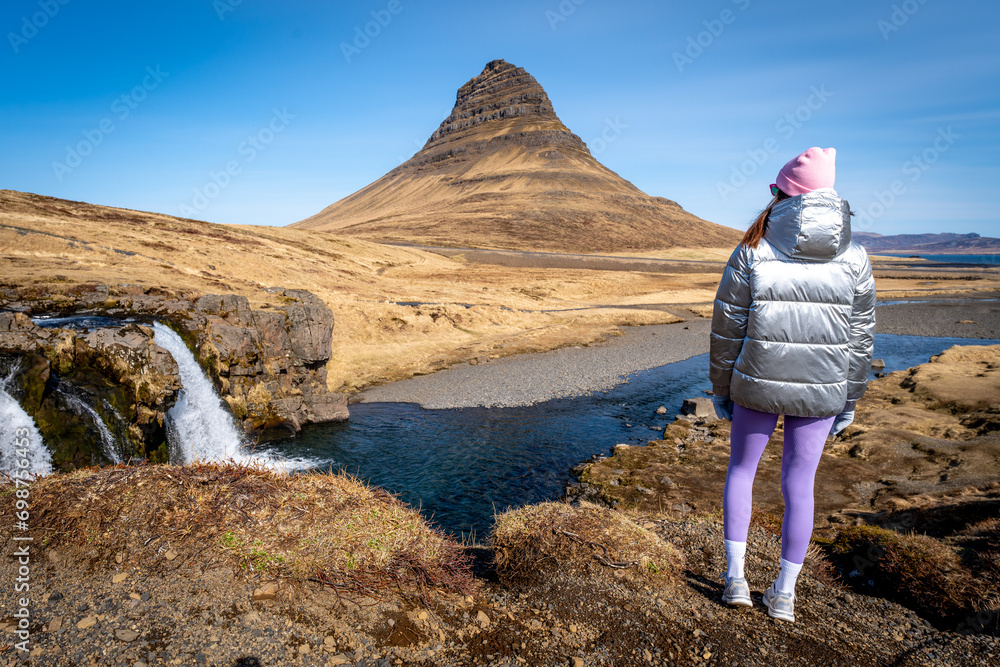 Naklejka premium Woman from behind in Kirkjufell, Iceland