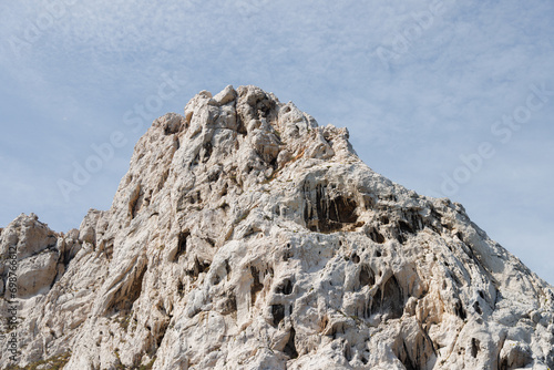 Sandy rock against a backdrop of blue sky.