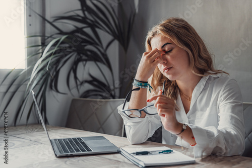 Stressed tired woman in pain having strong terrible headache attack after computer laptop study, fatigued exhausted girl suffering from chronic migraine massaging temples to relieve head ache tension.